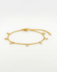 Gold bracelet with small round charms on a white background