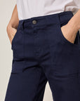 Navy pants worn by a person against a neutral background