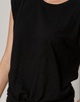 Black sleeveless top worn by a person on a neutral background