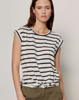 Woman wearing a black and white striped t-shirt against a plain background