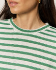 Close-up of a person wearing a green and white striped shirt with a neutral background