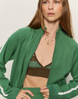 Woman wearing a green tracksuit with a plain background