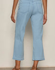 Light blue jeans worn by a person on a plain background