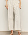 Person wearing white pinstripe pants with a plain background