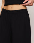 Person wearing a black skirt with a plain background