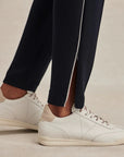 White sneakers worn with black pants on a neutral background