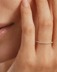 Close-up of a hand with a ring on a neutral background