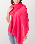 Woman wearing a bright pink scarf on a white background