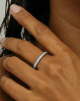Close-up of a hand wearing a silver ring with a blurred background