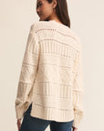 Woman wearing a cream-colored knitted sweater on a beige background