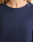 Navy blue ribbed sweater worn by a person with blonde hair.