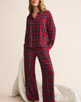 Woman wearing red plaid pajamas on a beige background