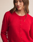 Woman wearing a red cardigan with a beige background