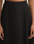 Black skirt worn by a person against a neutral background