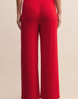 Red wide-leg pants worn by a person on a beige background