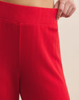 Red pants being worn against a beige background