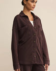 Woman wearing a brown jacket on a beige background