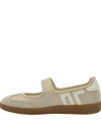 A single women's Mary Jane shoe in beige faux leather and suede, featuring a hook-and-loop strap, a textured white side logo, and a brown gum sole, shown against a plain white background.