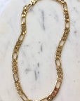 Gold chain necklace on a marble surface