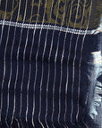 Close-up of a dark blue fabric with white stripes and intricate patterns.