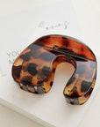 Tortoiseshell neck pillow on a white surface with a blurred background