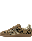 A low-top sneaker featuring a leopard print pattern on the side panels, tan suede overlays, a metallic gold side stripe, and a gum brown sole, shown against a plain white background.