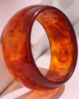 Amber-colored bangle on a light fabric background