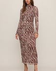 Woman wearing a zebra print dress on a plain background