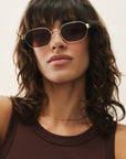 Woman wearing sunglasses with a neutral background