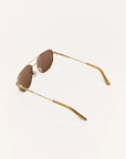 Gold-framed sunglasses with brown lenses on a white background