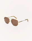 Gold-framed sunglasses with brown lenses on a white background