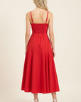 Red dress worn by a model on a beige background