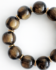 Brown beaded bracelet with gold accents on a white background