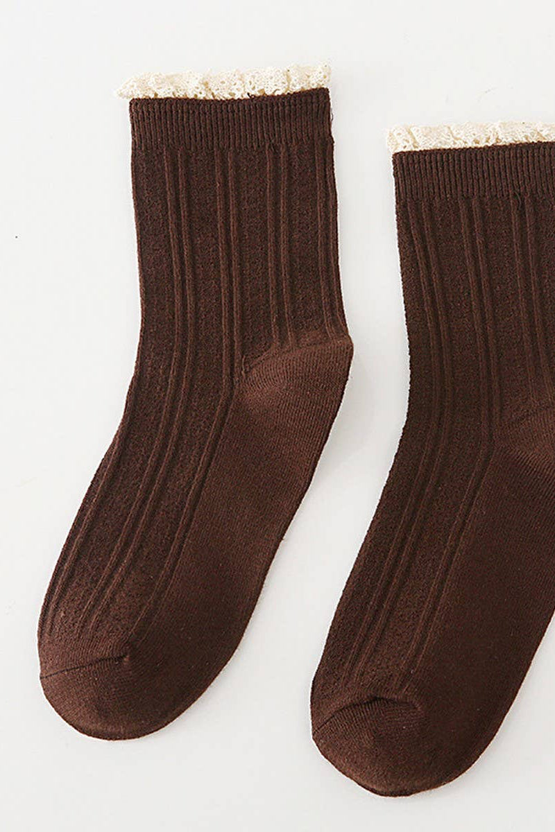 Pair of brown socks with white trim on a light gray background