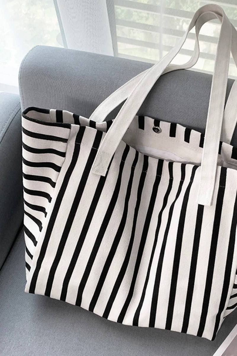 Black and white striped tote bag on a gray couch