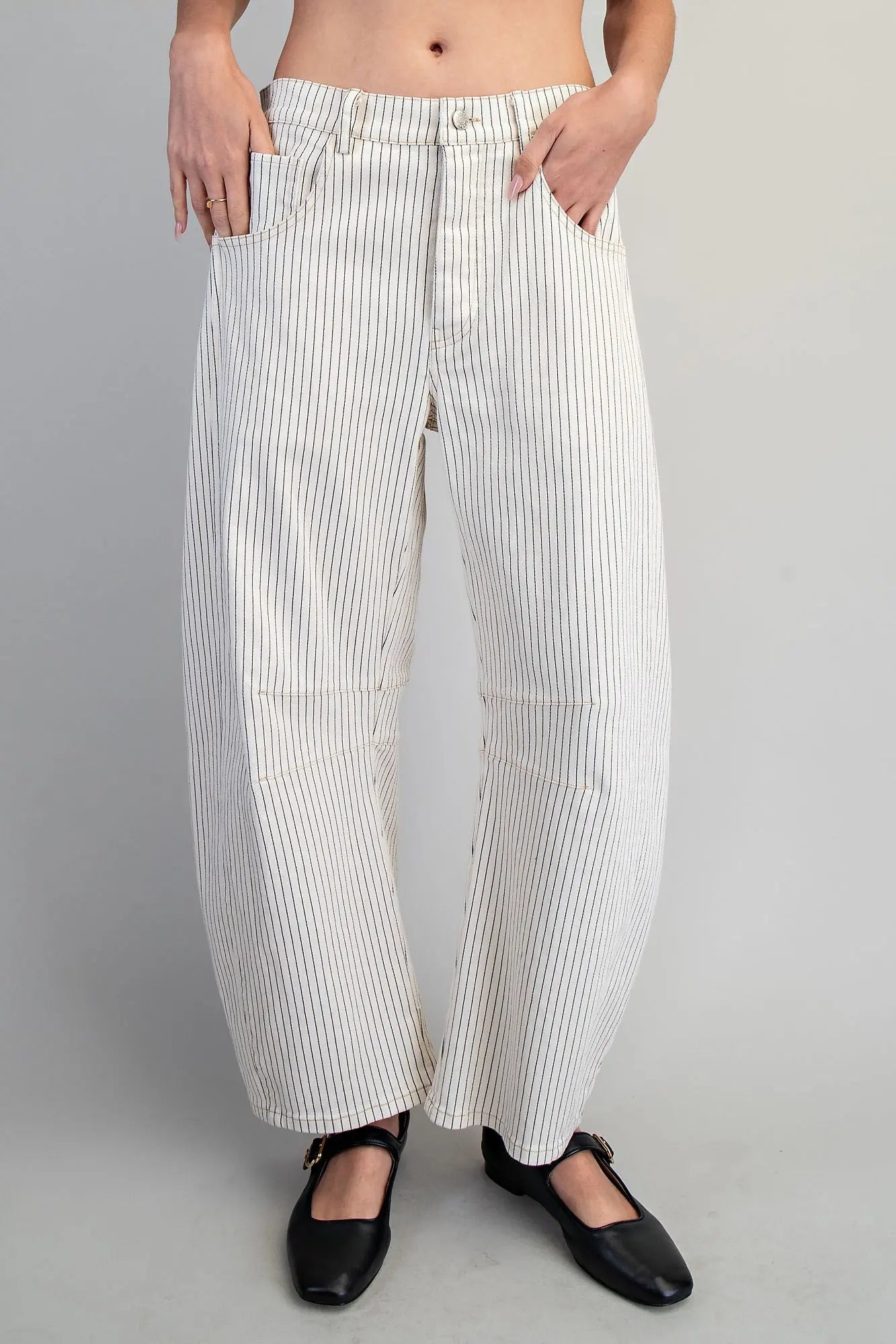 White striped pants worn by a person on a gray background