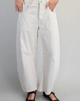 White striped pants worn by a person on a gray background
