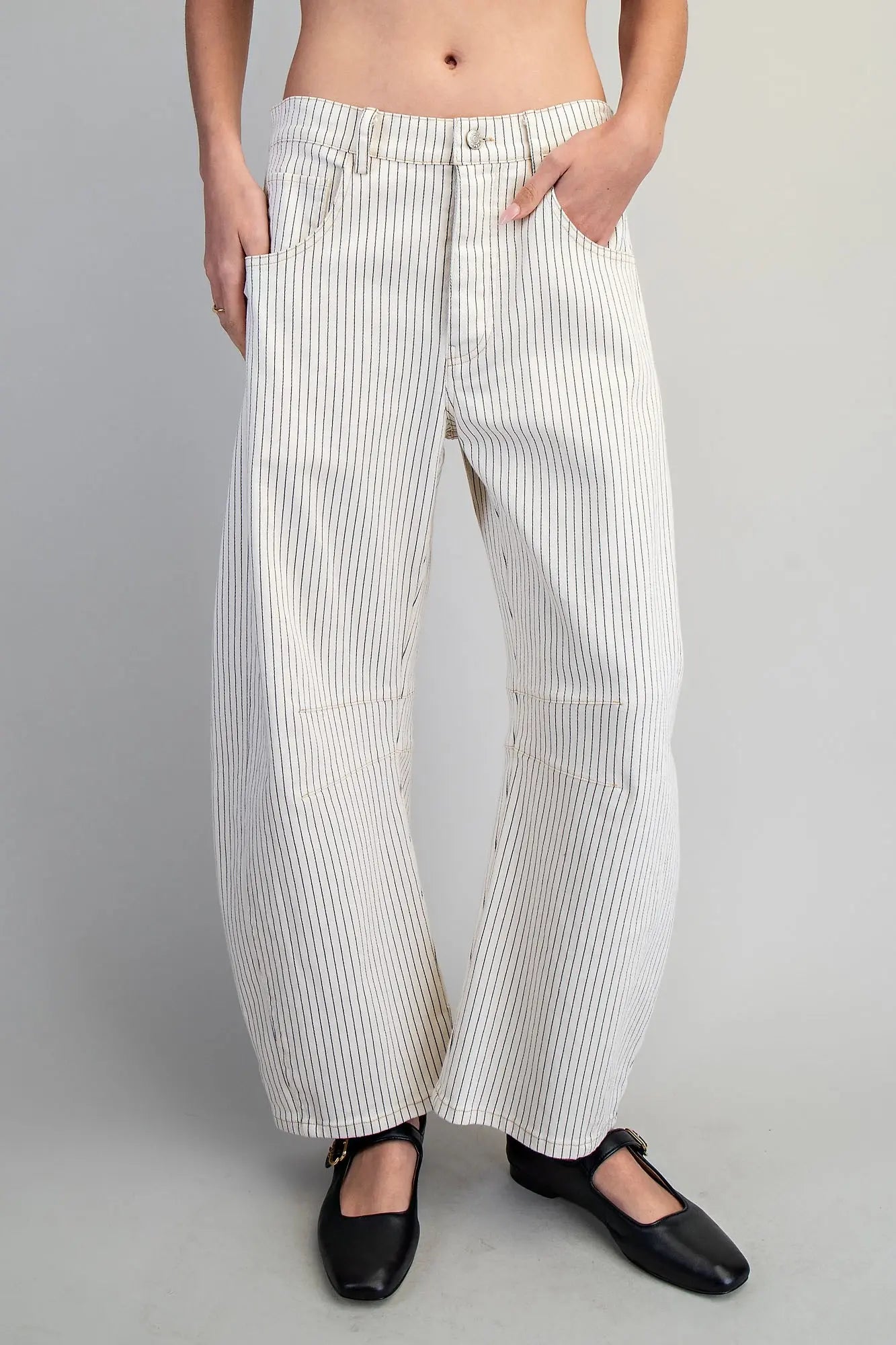 Person wearing white striped pants on a gray background