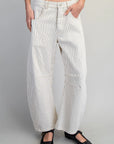 Person wearing white striped pants on a gray background
