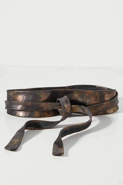 Worn leather belt on a light gray background