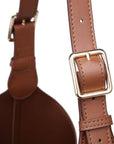 Brown leather strap with gold buckle on a white background