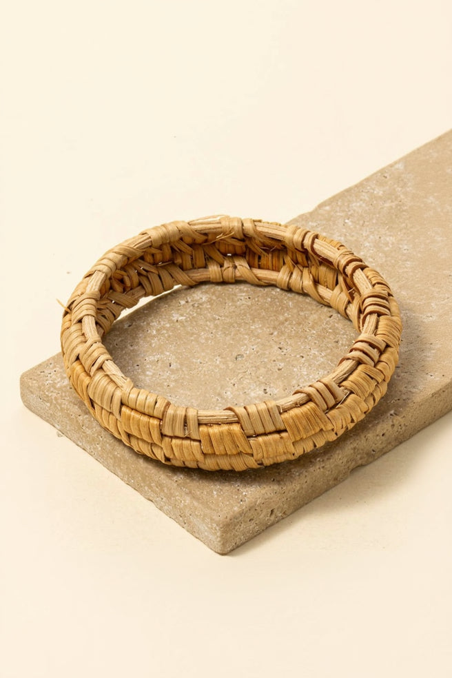 Woven rattan coaster on a stone surface