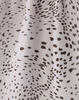 Close-up of a fabric with black spotted pattern on a gray background