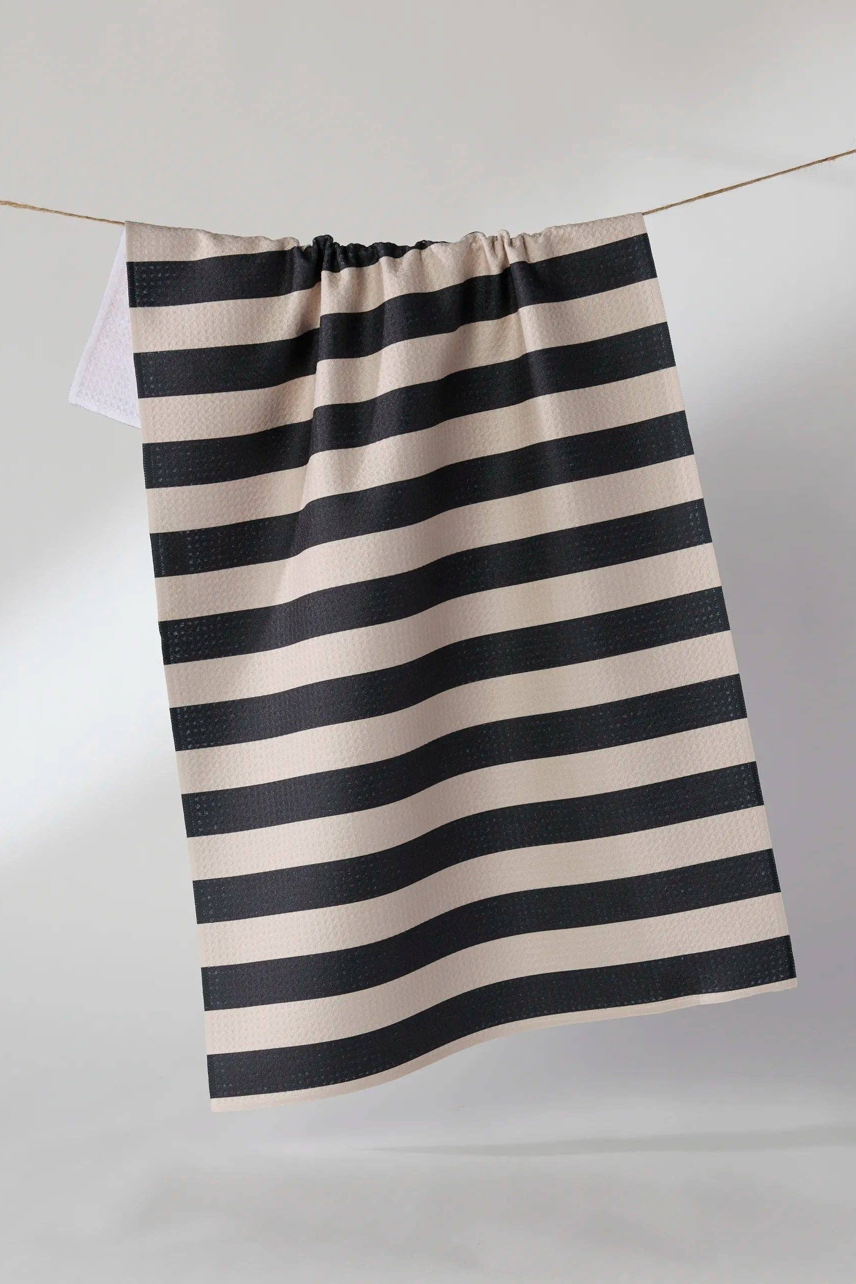 Black and white striped fabric hanging on a line against a plain background