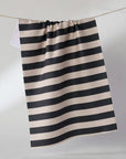 Black and white striped fabric hanging on a line against a plain background