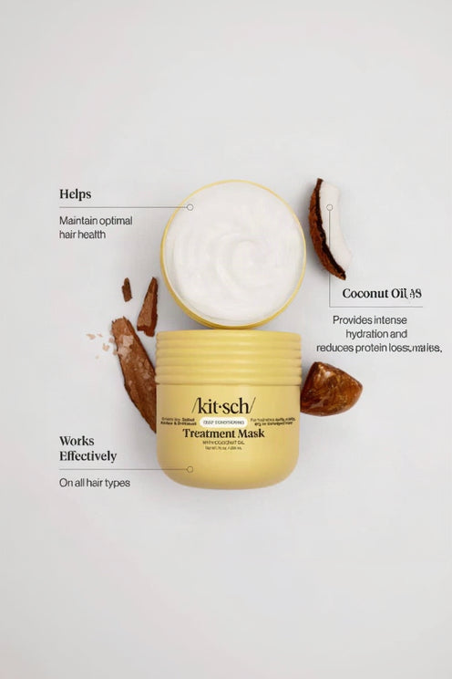 A jar of Akit-sch Deep Conditioning Coconut Oil Treatment Mask is shown open with white cream visible, surrounded by coconut pieces on a light gray background with callout text describing benefits.