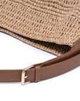 Woven straw bag with a brown leather strap on a white background