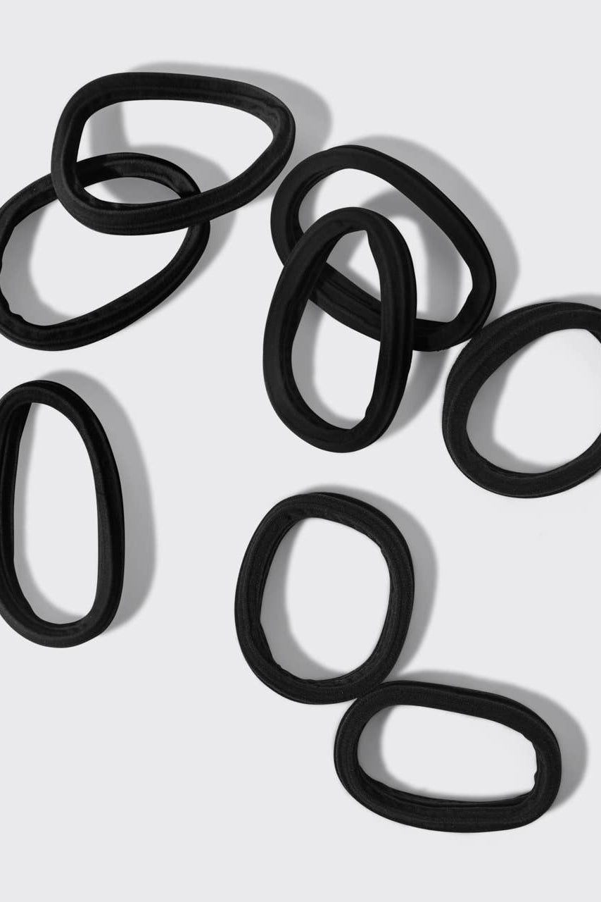 Set of black hair ties on a light gray background
