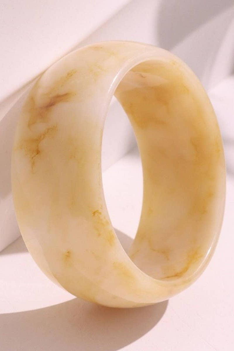 Beige stone ring on a light fabric background