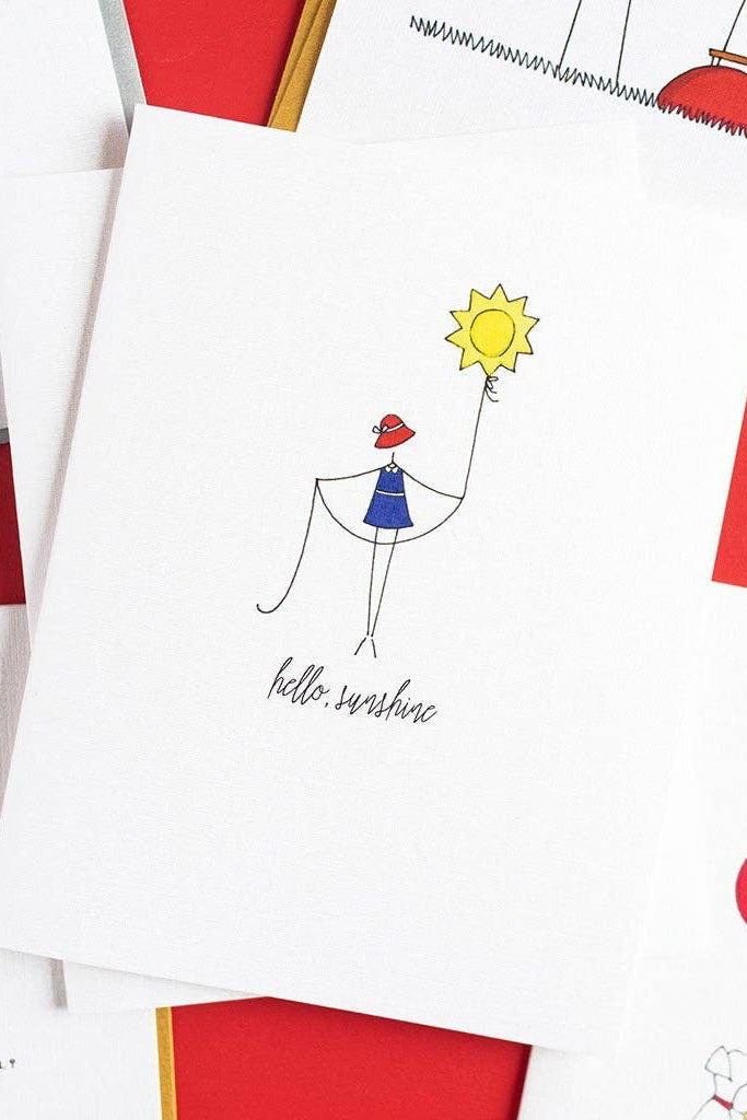 Notebook with 'hello, sunshine' illustration and colorful design elements on a white background.